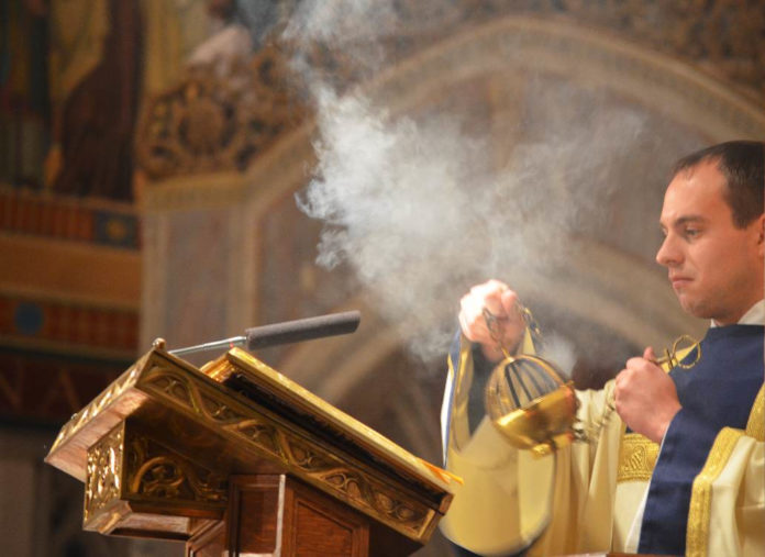 Deacon Jeremy Miller, who was incensing the Bible before reading Luke 4-16-21 during the Chrism Mass (March 26, 2013) at Rosary Cathedral.